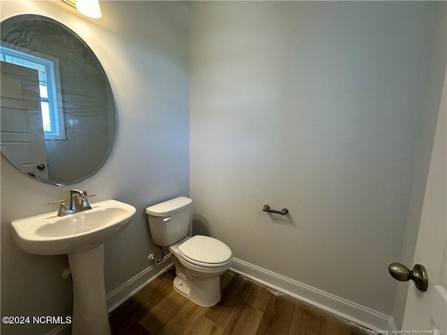 bathroom with toilet and hardwood / wood-style floors