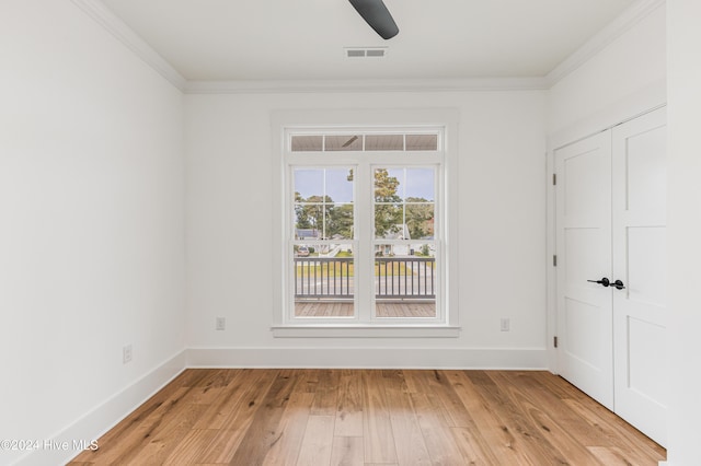 spare room with light wood-type flooring and ornamental molding