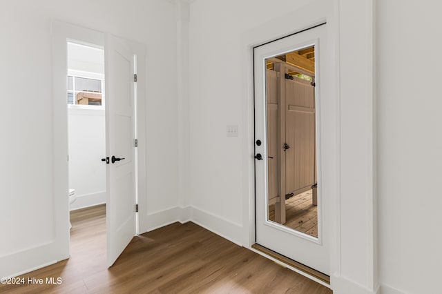 corridor with hardwood / wood-style floors