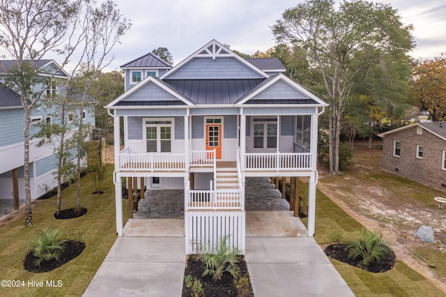 view of front of home featuring covered porch, a front lawn, and a carport