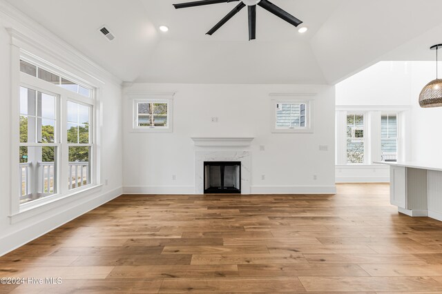 unfurnished living room with a fireplace, light hardwood / wood-style floors, high vaulted ceiling, and ceiling fan