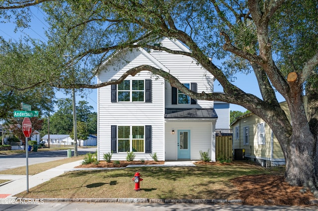 view of front property featuring a front lawn and cooling unit