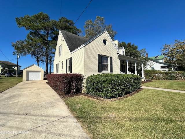 view of side of home featuring a garage, a yard, and an outdoor structure