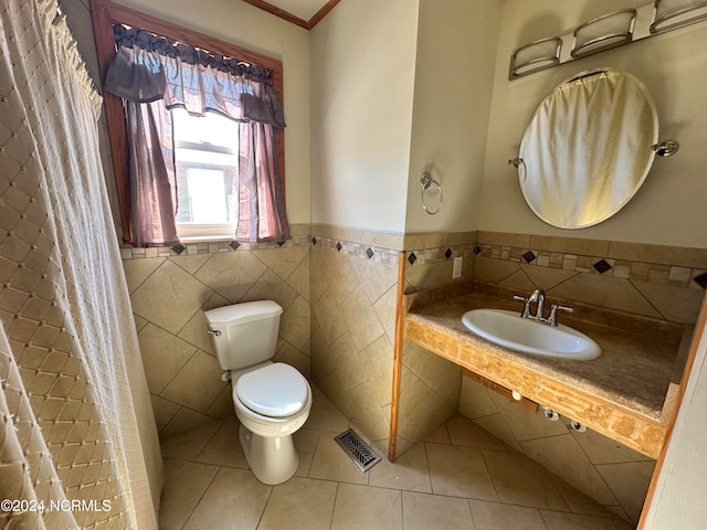 bathroom with tile patterned floors, toilet, tile walls, and sink