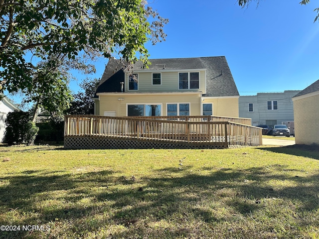 rear view of house featuring a yard and a wooden deck