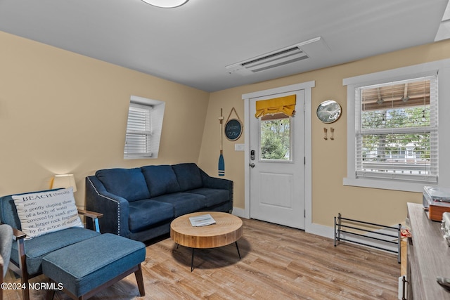 living area featuring light wood-type flooring, visible vents, and baseboards