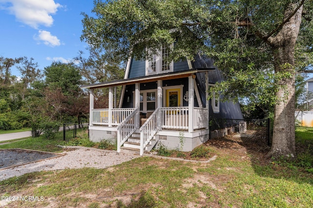 view of front of house with crawl space, a porch, and fence