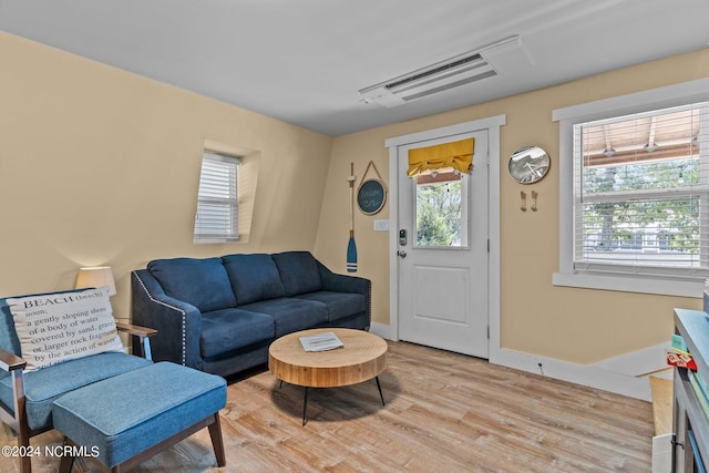 living area with light wood finished floors, baseboards, and visible vents