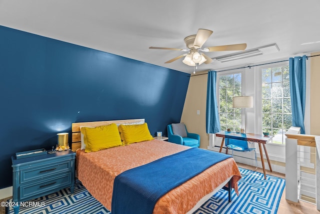 bedroom featuring ceiling fan, wood finished floors, and visible vents