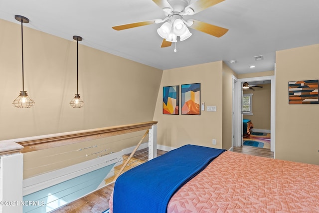 bedroom with ceiling fan, baseboards, wood finished floors, and visible vents