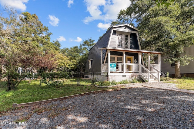 view of front of house with a front yard and covered porch