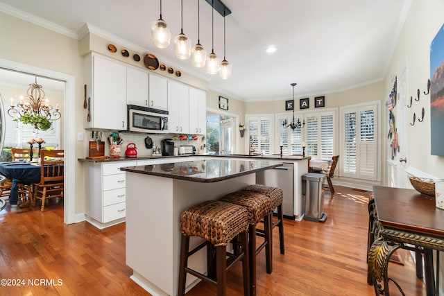 kitchen featuring hardwood / wood-style flooring, a kitchen bar, a chandelier, and stainless steel appliances