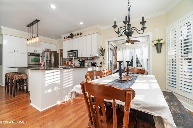 dining space featuring crown molding, light hardwood / wood-style flooring, and a healthy amount of sunlight