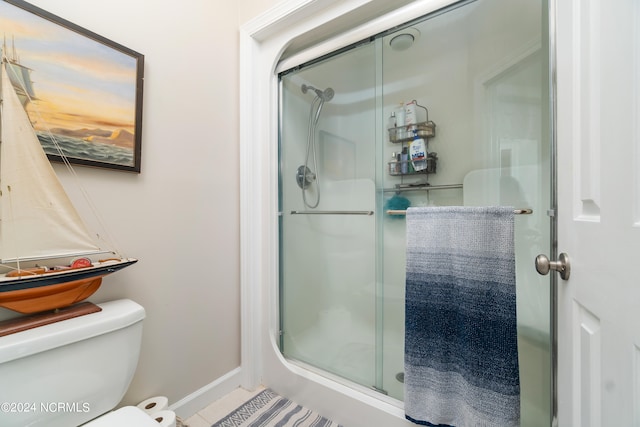 bathroom with tile patterned floors, an enclosed shower, and toilet