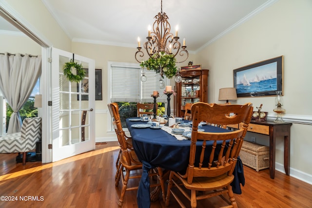 dining room with ornamental molding, hardwood / wood-style floors, and a chandelier