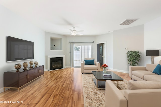 living room featuring light hardwood / wood-style flooring and ceiling fan