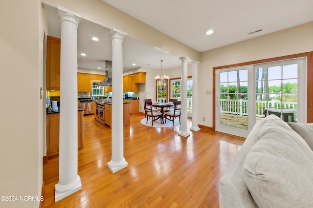 living room featuring light hardwood / wood-style floors, a notable chandelier, and a healthy amount of sunlight