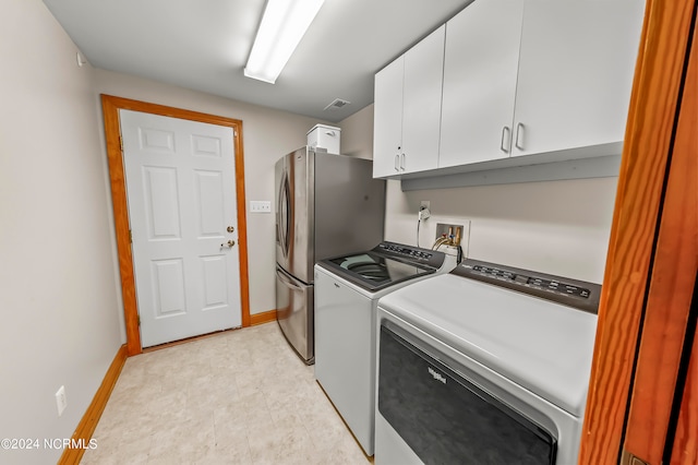 washroom featuring separate washer and dryer and cabinets