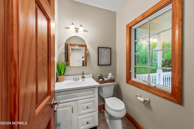 bathroom featuring vanity, tile patterned floors, toilet, and a healthy amount of sunlight