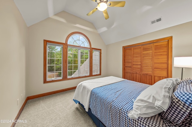 carpeted bedroom featuring ceiling fan, a closet, and vaulted ceiling