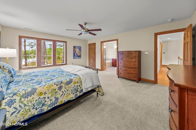 carpeted bedroom with ceiling fan and ensuite bath