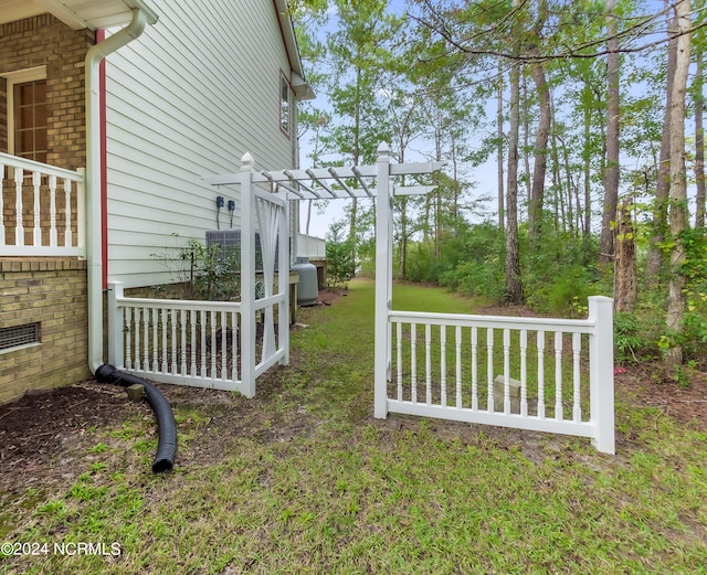 view of yard with central AC and a pergola