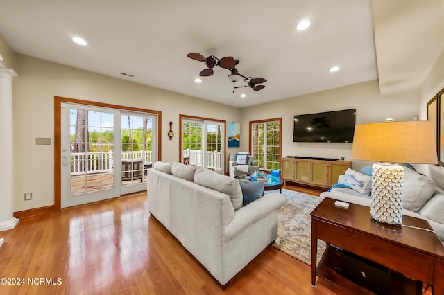 living room with ceiling fan, hardwood / wood-style flooring, and decorative columns