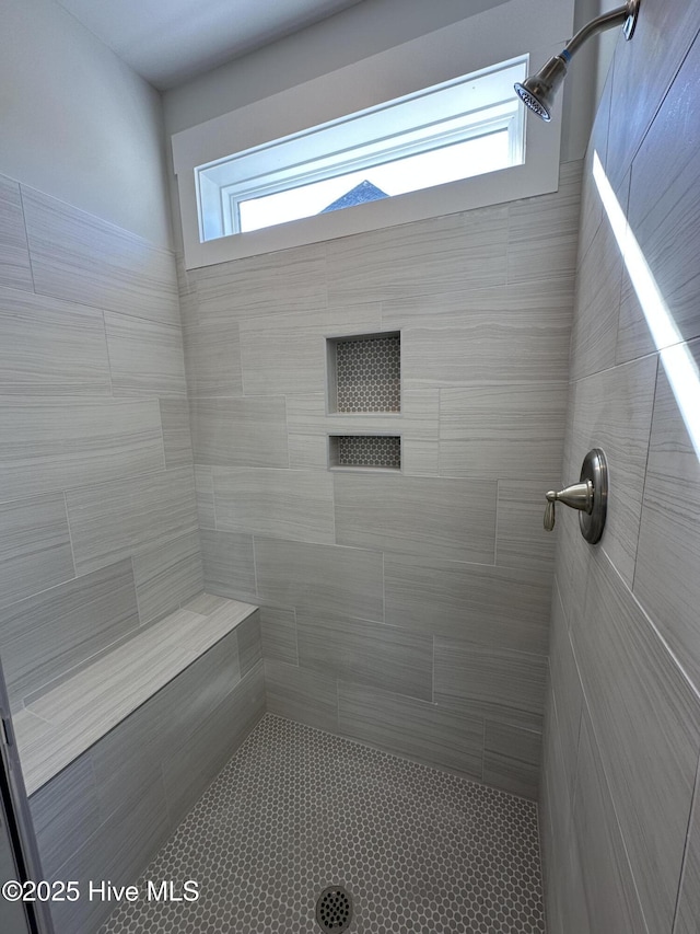 full bath featuring a healthy amount of sunlight and a tile shower