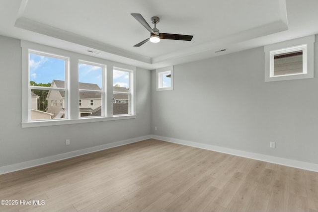 unfurnished room with a tray ceiling, light hardwood / wood-style flooring, and ceiling fan