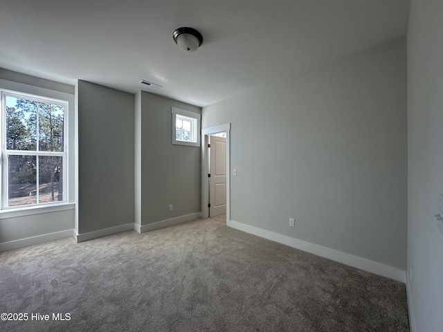 carpeted empty room featuring visible vents and baseboards