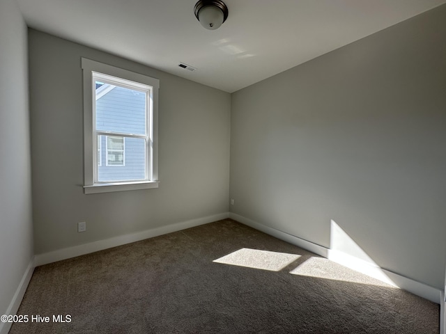 carpeted empty room featuring visible vents and baseboards