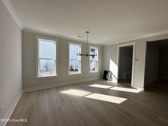 unfurnished dining area with a wealth of natural light, baseboards, crown molding, and wood finished floors