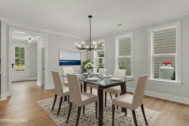 dining room with crown molding, an inviting chandelier, and light hardwood / wood-style flooring