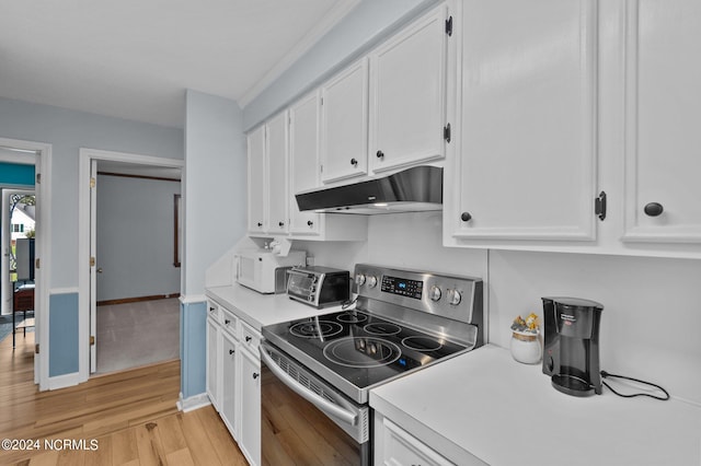 kitchen featuring stainless steel electric range oven, light hardwood / wood-style floors, and white cabinetry