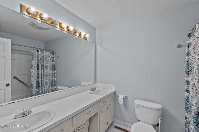 bathroom featuring a shower with curtain, vanity, tile patterned flooring, toilet, and a textured ceiling