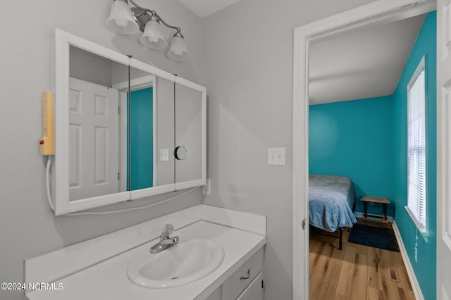 bathroom featuring vanity, hardwood / wood-style floors, a textured ceiling, and a wealth of natural light