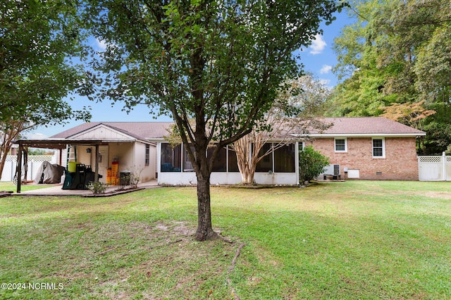 back of house featuring a sunroom and a lawn