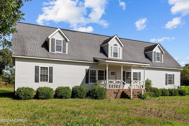 cape cod-style house featuring covered porch and a front yard