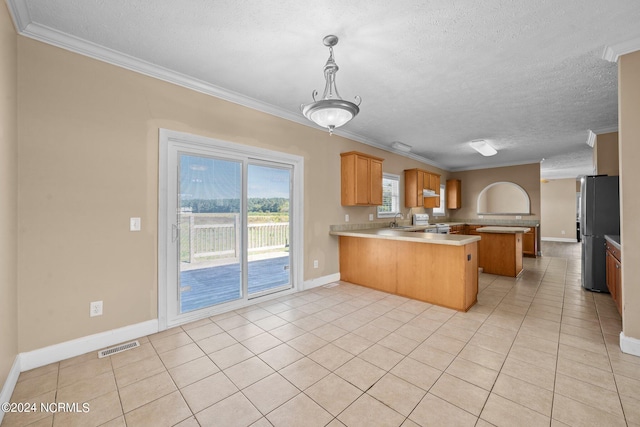 kitchen featuring stainless steel fridge, kitchen peninsula, crown molding, and light tile patterned floors