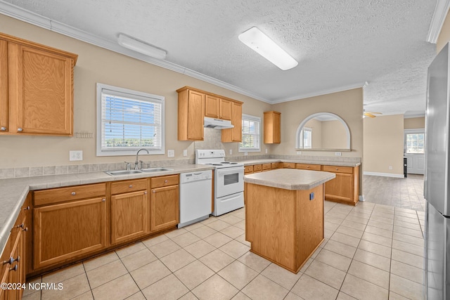 kitchen with a healthy amount of sunlight, sink, white appliances, and a center island