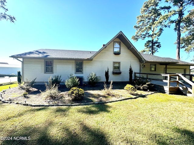 rear view of property featuring a yard, cooling unit, and a wooden deck