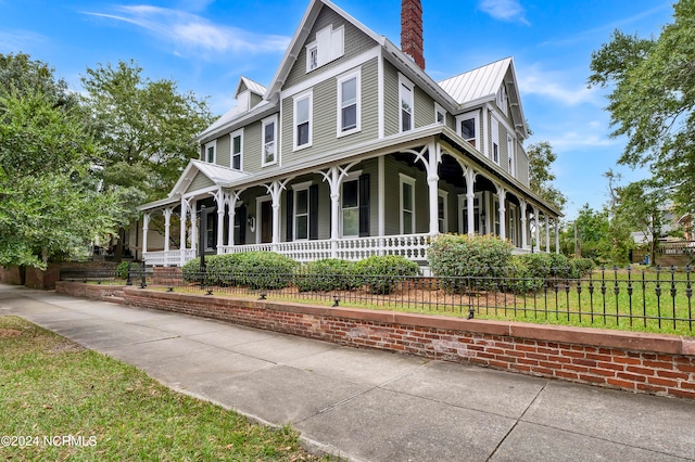 view of front of home featuring covered porch and a front lawn