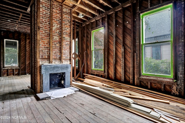 misc room with brick wall and hardwood / wood-style floors