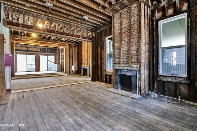 unfurnished living room featuring a fireplace with raised hearth and hardwood / wood-style flooring