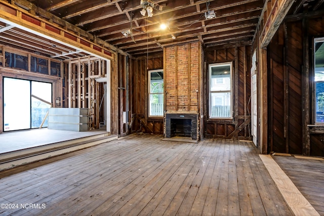 miscellaneous room featuring a brick fireplace, wood-type flooring, and ceiling fan