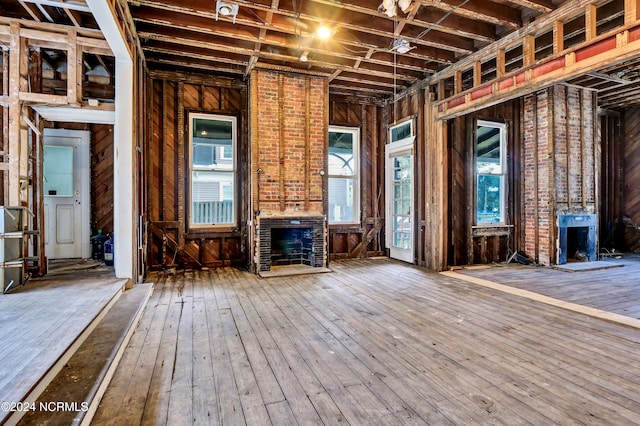 misc room with wooden walls, a fireplace, and hardwood / wood-style floors