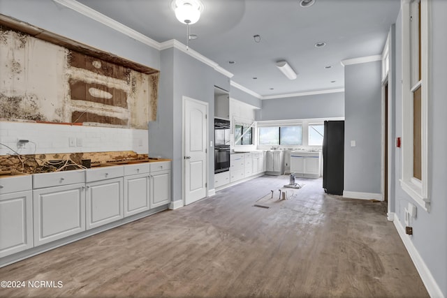 kitchen featuring decorative backsplash, crown molding, and white cabinets