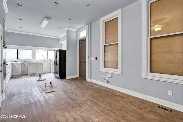 unfurnished living room with ornamental molding and wood-type flooring