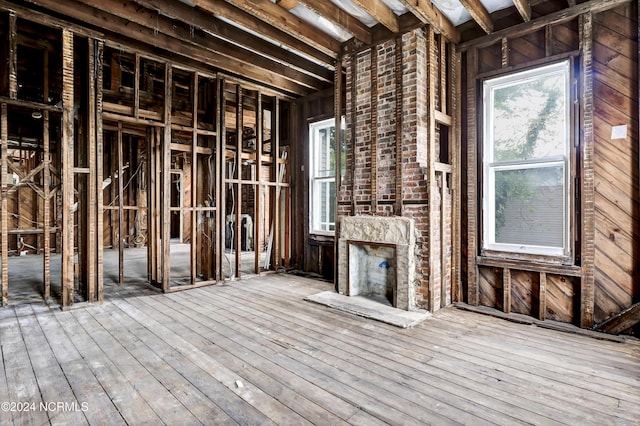 miscellaneous room with hardwood / wood-style floors and an outdoor brick fireplace