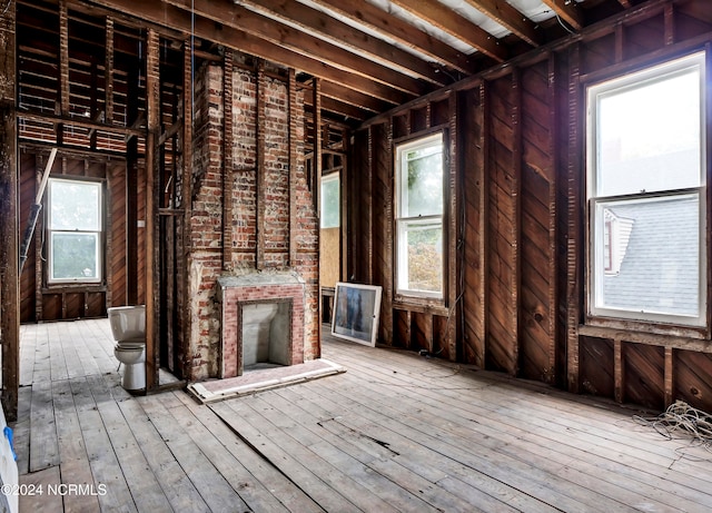 misc room with a brick fireplace, hardwood / wood-style flooring, and a healthy amount of sunlight